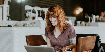 Frau lacht am Laptop
