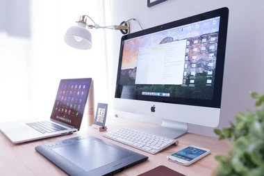 Schreibtisch mit Monitor Tastatur Tablet und Mobiltelefon