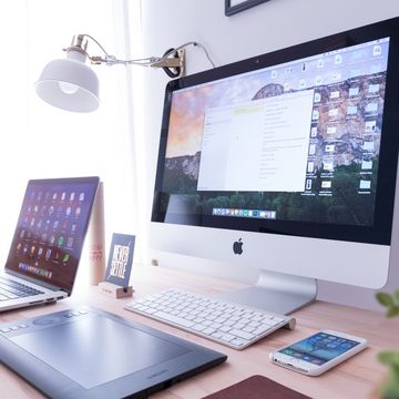 Schreibtisch mit Monitor Tastatur Tablet und Mobiltelefon