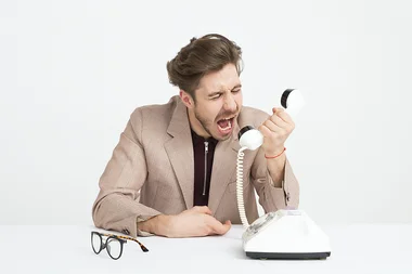Mann brüllt in Telefonhörer