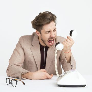 Mann brüllt in Telefonhörer